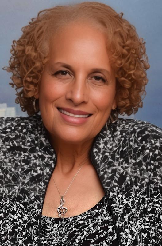 A woman with curly hair wearing a black and white jacket.