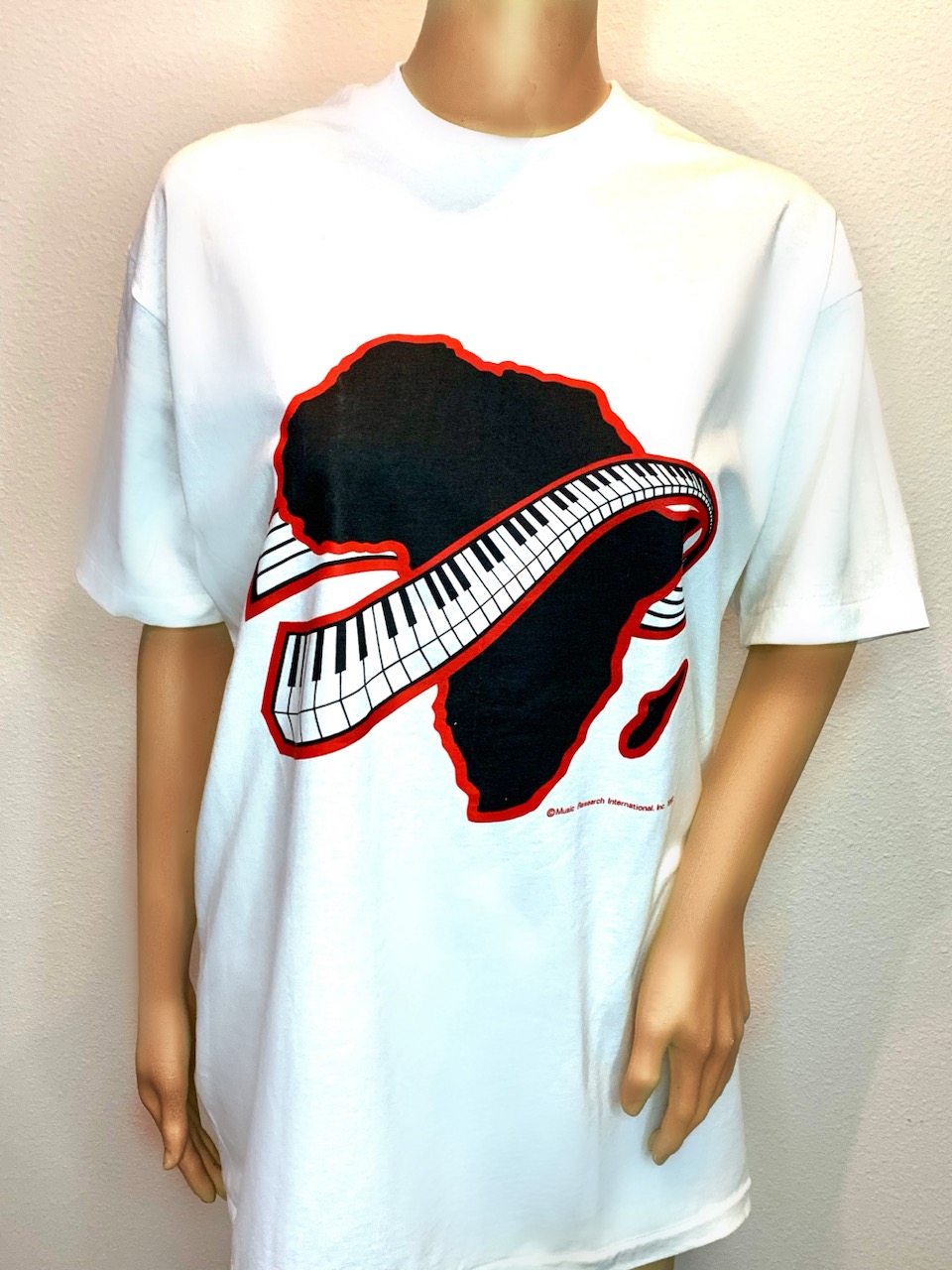 A white t-shirt with a piano keyboard on it.